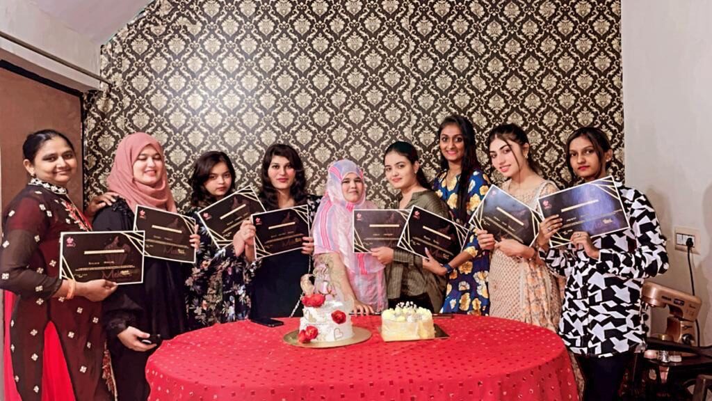 Maherin posing with students of her professional cake baking classes. Story by The Winged Women