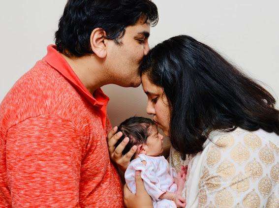 Shilpa and Amogh posing with their surrogate baby. Story shows an IVF success story